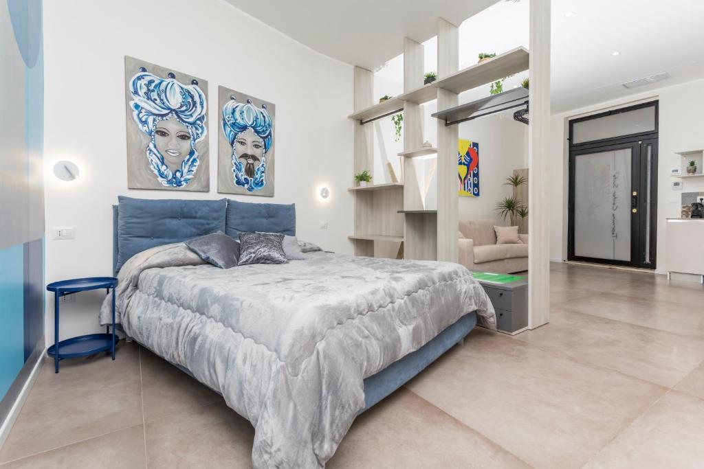 a bedroom with a blue bed in a white room at Taormina Center Suite in Taormina