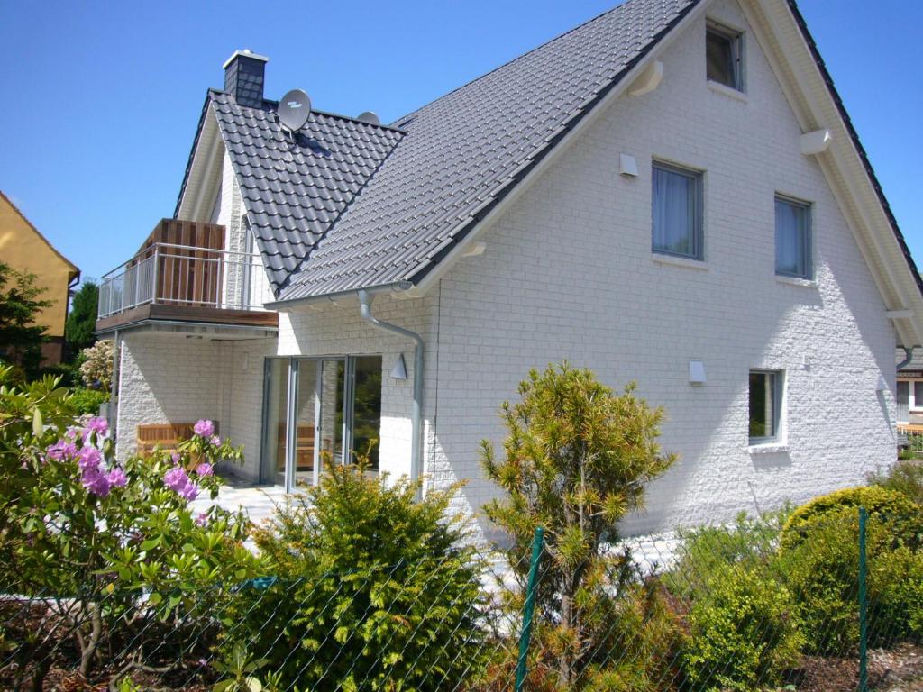 une maison blanche avec un toit gris dans l'établissement Strandamsel, à Binz