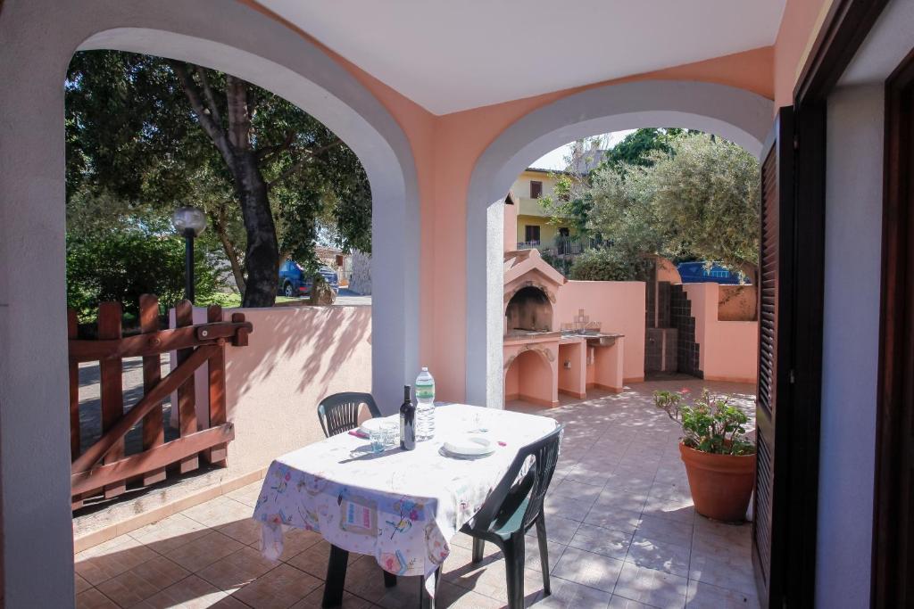 a table and chairs sitting on a patio with an open doorway at mirtagru casa della Sughereta in Budoni