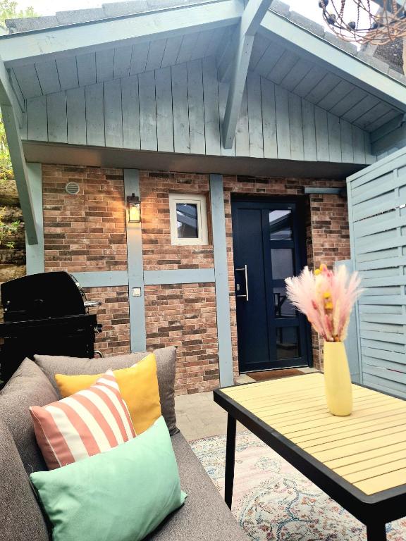 a patio with a couch and a table and a door at Tiny House am Kaiserstuhl in Ihringen