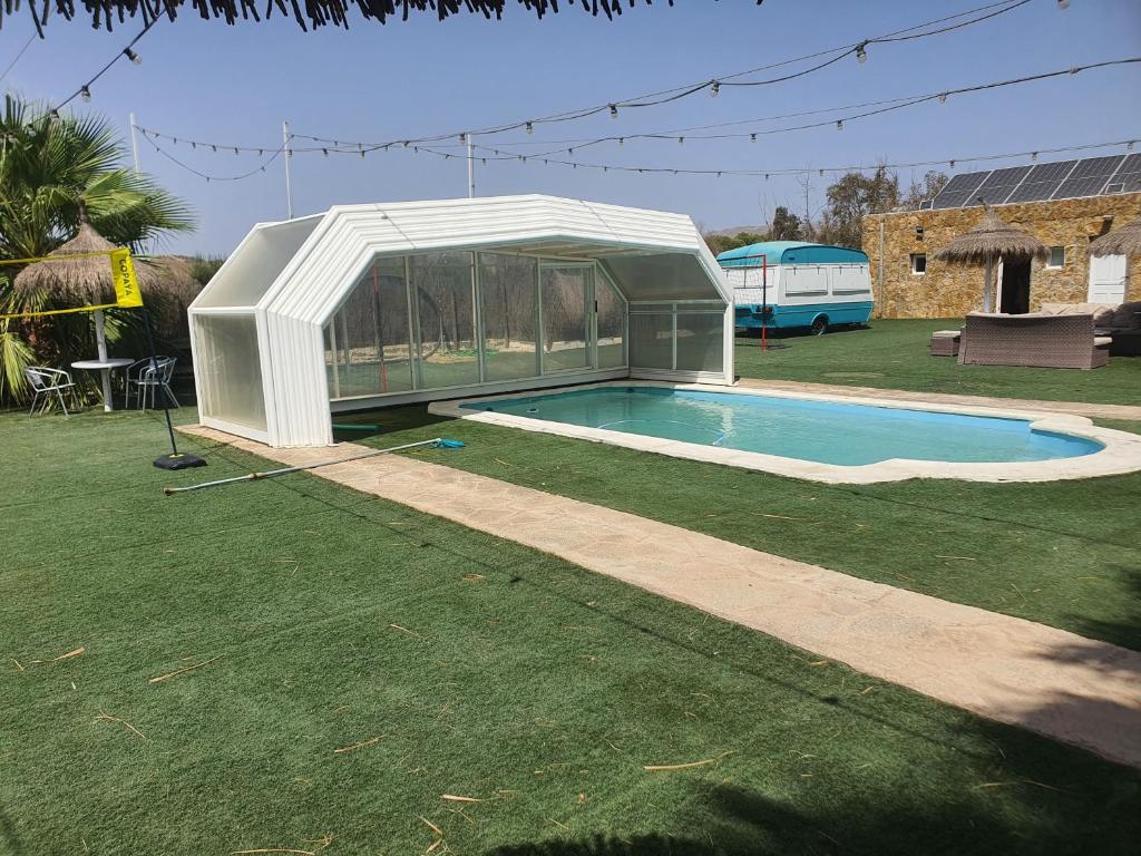 a swimming pool in a greenhouse next to a house at Villa Dehesa in Tabernas