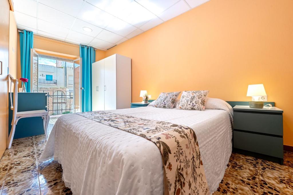 a bedroom with a large bed with orange walls at Loft Sant Joan in L'Ametlla de Mar