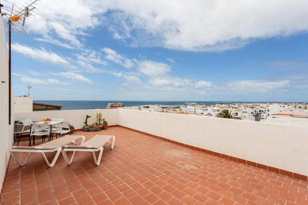 a balcony with a table and chairs and the ocean at La Casa Bianco in El Cotillo