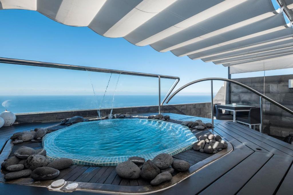 a hot tub on the deck of a house at Spr Ático in Santa Úrsula