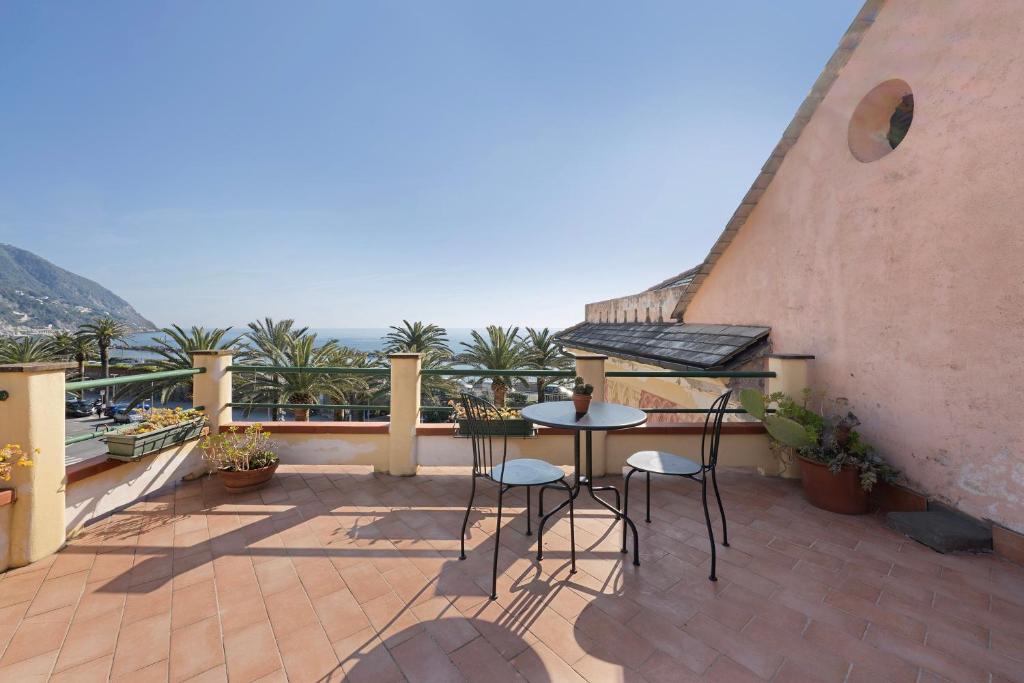 a patio with a table and chairs on a balcony at Casa Marcone in Moneglia