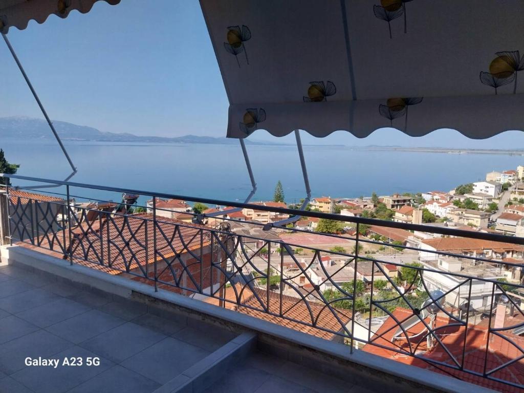 a balcony with a view of a city and the water at Menidi Sea View 302 in Menídion