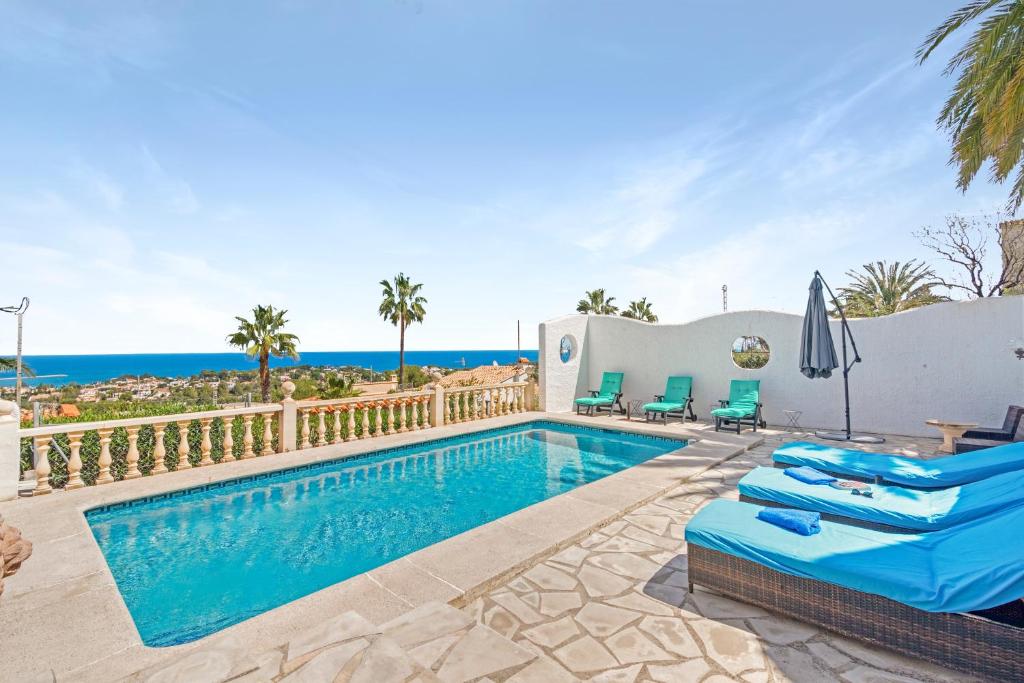a villa with a swimming pool and palm trees at Adriana in Denia