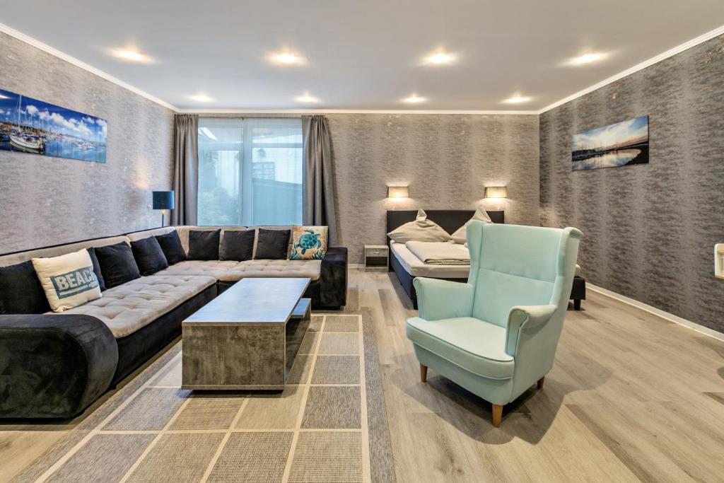 a living room with a couch and a table and a chair at Studioapartment am Hafen in Flensburg