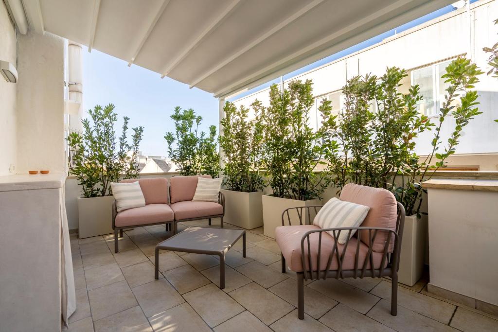 a balcony with chairs and potted plants on it at Civico40 Suite in Locorotondo