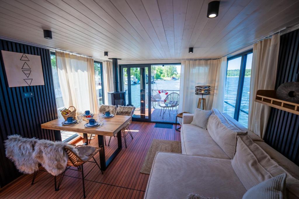 a living room with a couch and a table at Wohlfühl-Hausboot Elements Woma D13 in Fürstenberg
