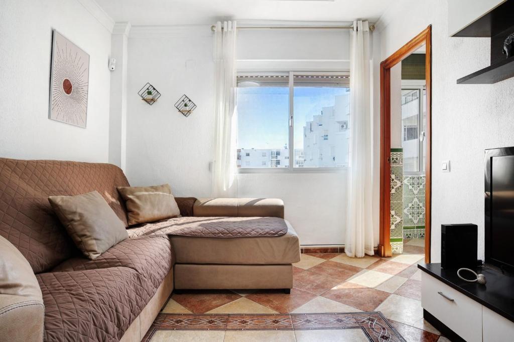 a living room with a couch and a window at Apartamento Faro de Barbate in Barbate