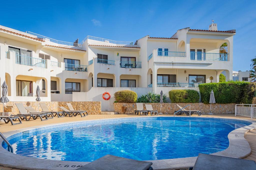 a villa with a swimming pool in front of a building at Norah’s House in Carvoeiro