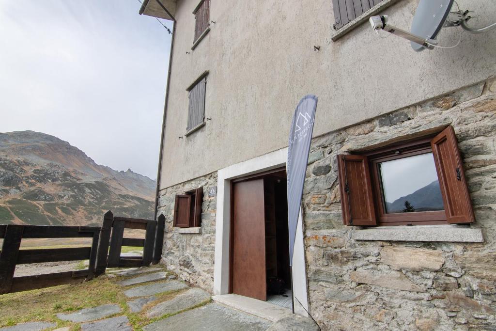 a building with a window and a sign next to it at Agriturismo Montespluga in Madesimo