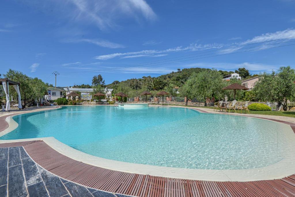a large swimming pool with blue water at Appartamenti Dolores in Campo nell'Elba