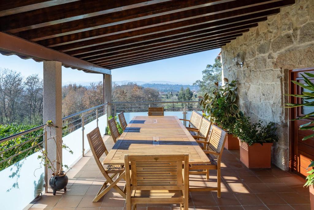 a wooden table and chairs on the balcony of a house at Lugar Da Xacra in Meder