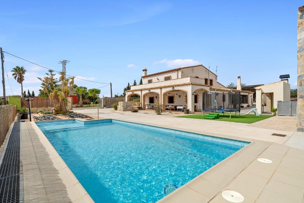 a swimming pool in front of a house at Mas del Vedell in L'Ampolla