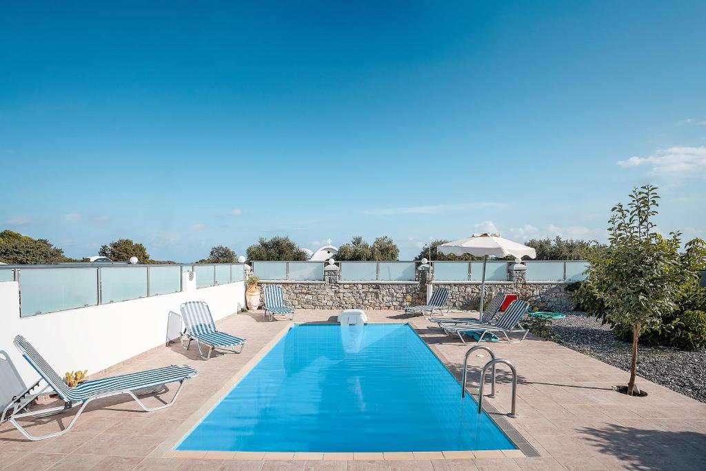a swimming pool on a patio with lounge chairs at Green Pearl in Lachania