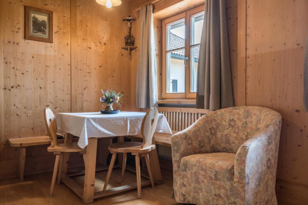 a dining room with a table and a chair at Haus Thurn Apartment A in Castelrotto