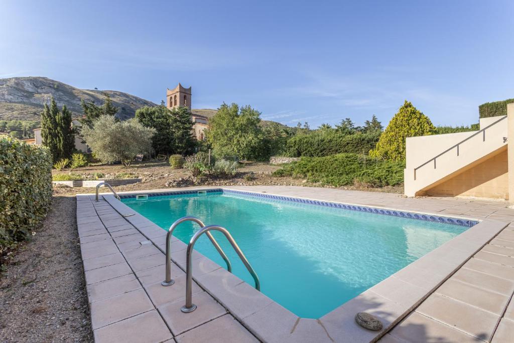 a swimming pool in front of a house at Gîte dels Ocells in Camélas