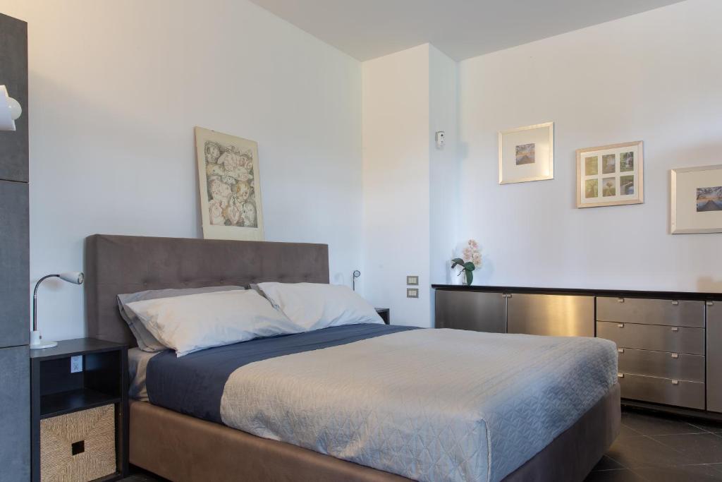 a bedroom with a large bed and a dresser at Studio Colline di Bardolino in Bardolino
