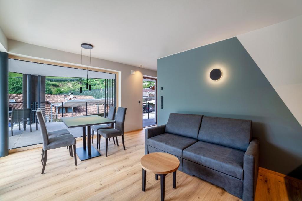 a living room with a couch and a table at Aktiv Lodge Meran - Terrace One in San Martino