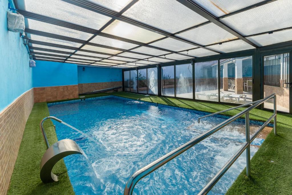 a large indoor swimming pool with glass windows at Casa Rural Kalfonso in Mascaraque