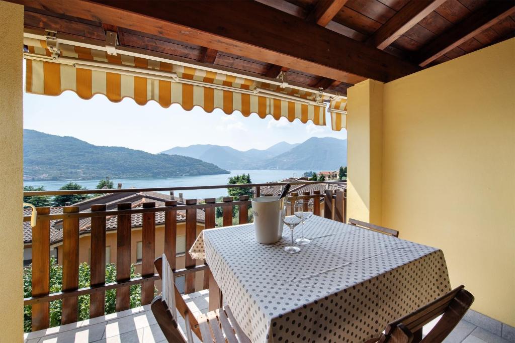 a table on a balcony with a view of the water at Miralago Marone Holiday House in Marone