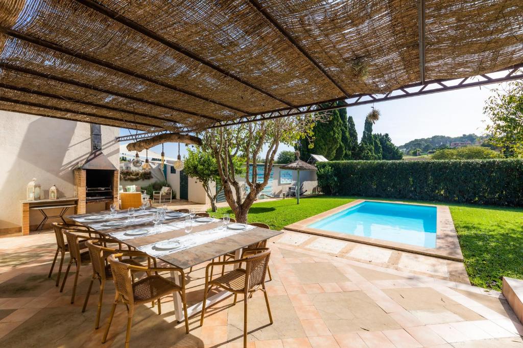 a patio with a table and chairs and a swimming pool at Es Collet in Manacor