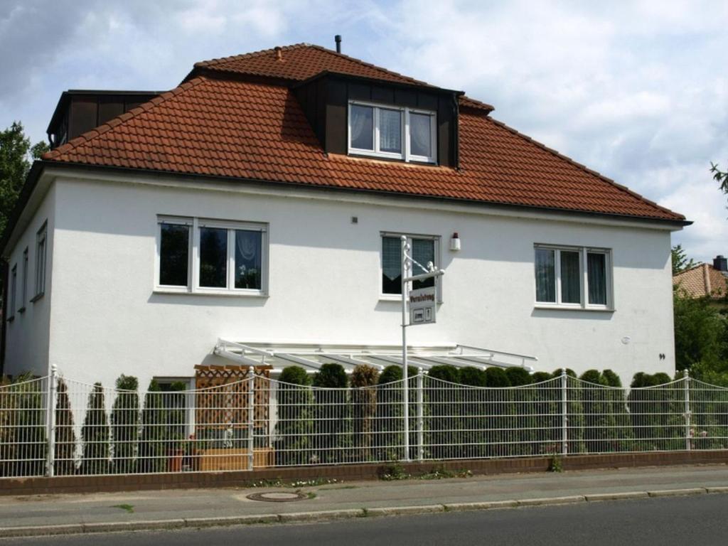 a white house with a red roof at Apartment Mengelberg in Markkleeberg