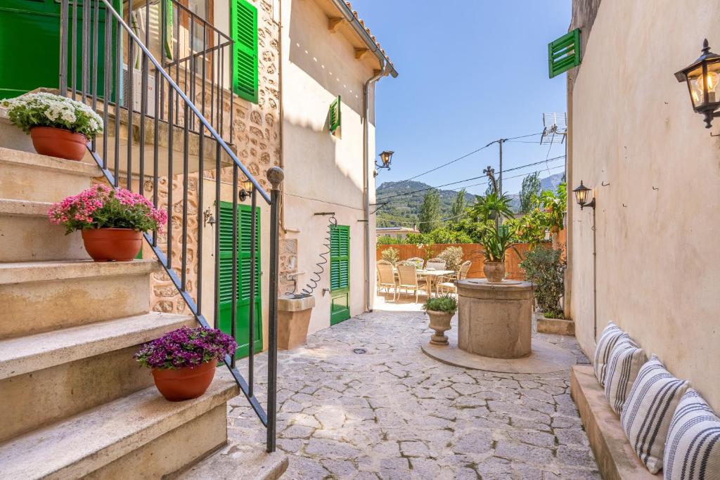 an alley with potted plants and stairs in a town at Casa Tramuntana in Sóller
