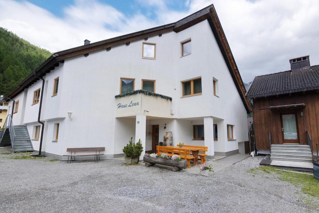 a large white building with a bench in front of it at Haus Lena in Solda