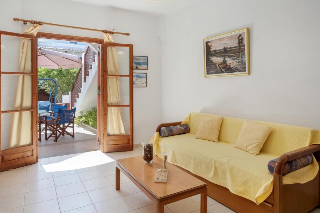 a living room with a yellow couch and a table at Studios Asterias 2 in Astypalaia