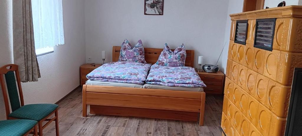 a bedroom with a bed and a chair at Zur Schmiede in Hasselförde
