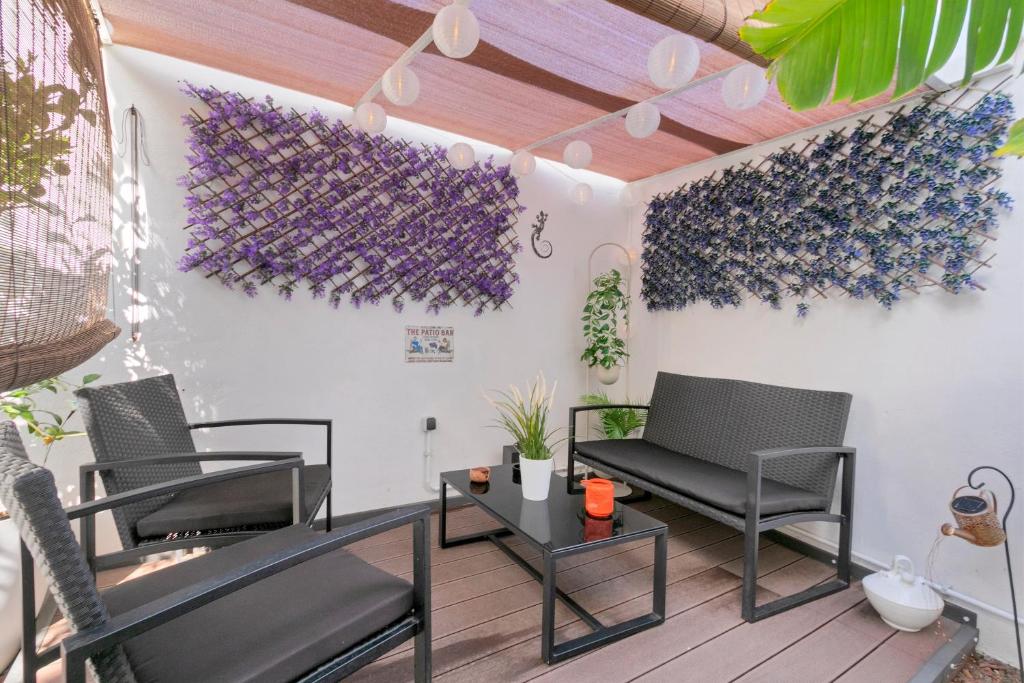 a patio with chairs and a table and purple flowers at Loft Cerca Del Mar Tenerife in Punta del Hidalgo