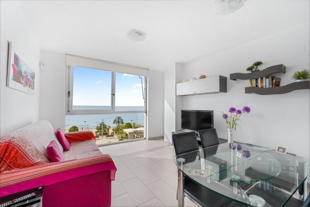 a living room with a pink couch and a glass table at Topete Alicante in Alicante