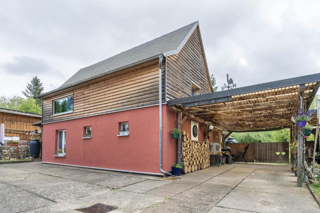 a large red building with a brown roof at Chalet Kunterbunt in Langenwetzendorf