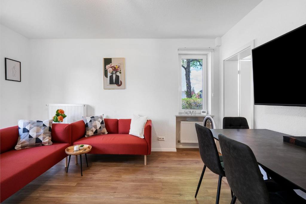 a living room with a red couch and a table at Ferienwohnung in München Eg in Munich