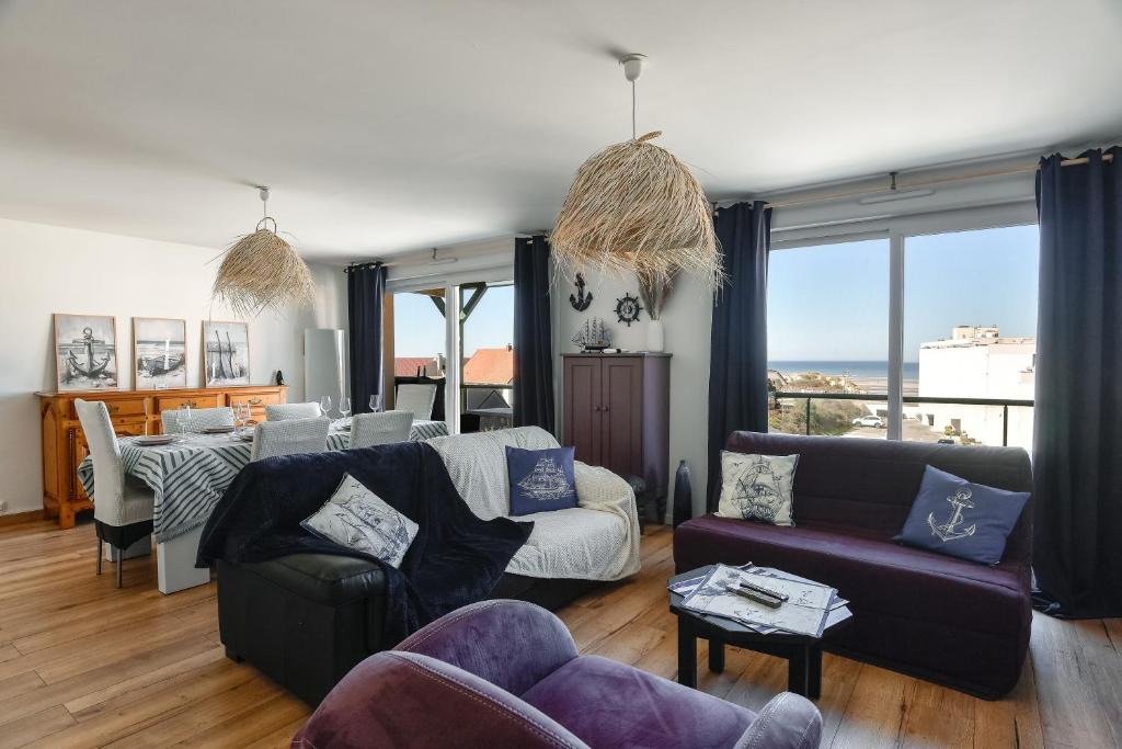 a living room with two couches and a table at La Madély in Camiers