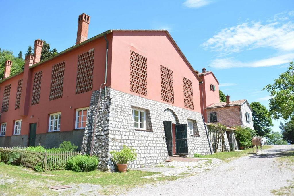 an old building with a horse standing in front of it at Agriturismo Monte Pu' in Castiglione Chiavarese