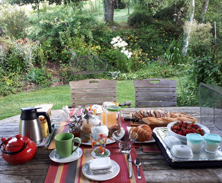 a picnic table with food and bread on it at Maison d'hôtes, Calme et Piscine in Habas