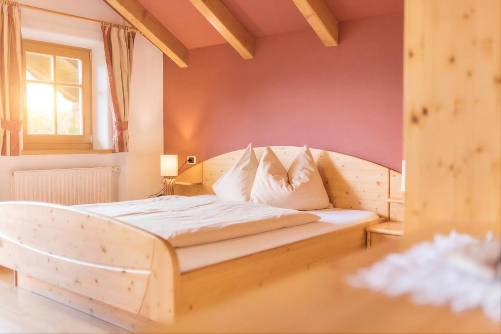 ein Schlafzimmer mit einem Holzbett in einem Zimmer in der Unterkunft Oberplunerhof - Fewo Kronplatz in Kiens