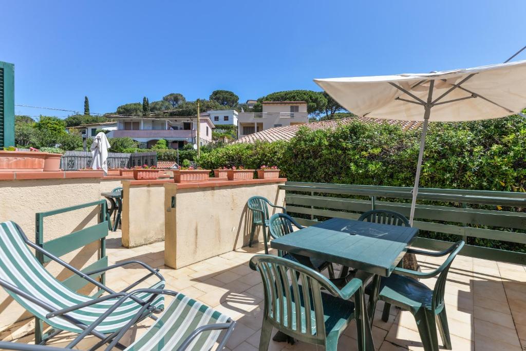 a table and chairs with an umbrella on a patio at Il Quadrifoglio 2 in Procchio