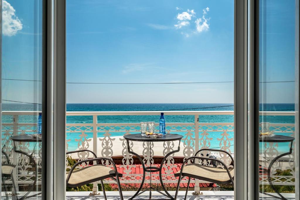 a table and chairs on a balcony with a view of the ocean at Angela sea view 7 in Kefallonia