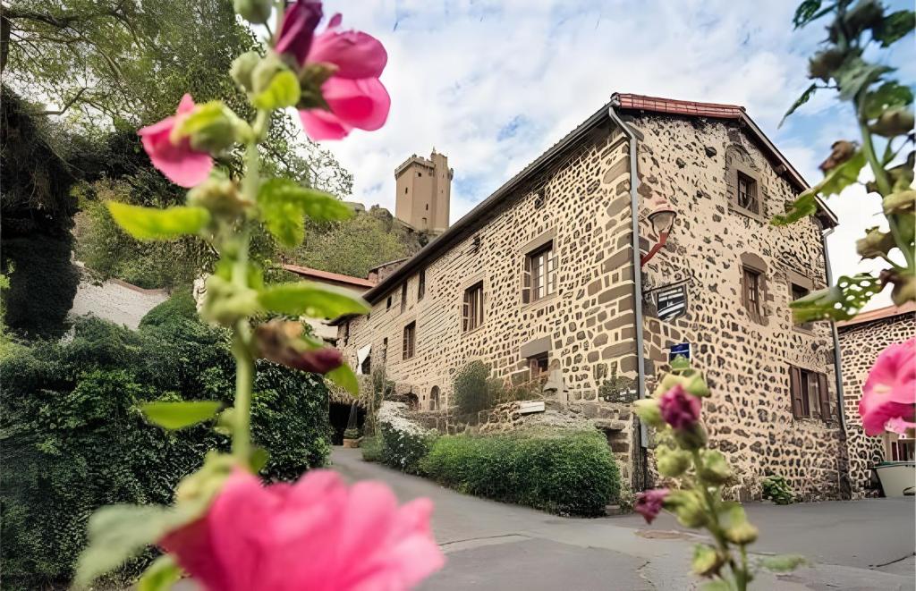 a building with pink flowers in front of it at La Gourmantine in Polignac