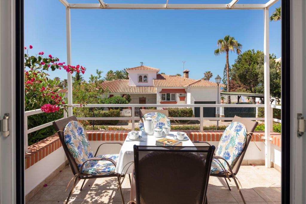 a table and chairs on a patio with a view of a house at Apartamento M 1 in Torrox Costa