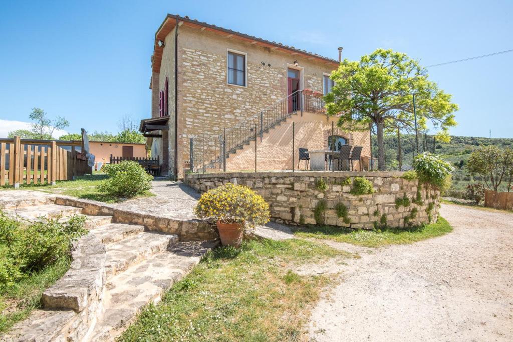 an external view of a house with a stone wall at Podere del Pereto Bio- 203 in Rapolano Terme