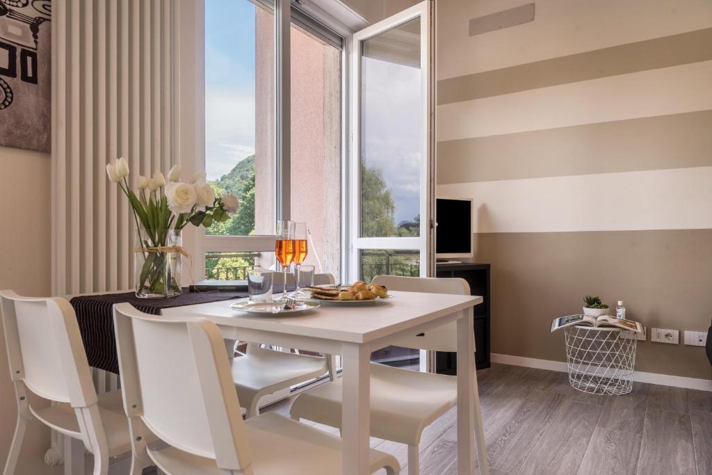 a dining room with a table and chairs and a window at Maison Bibi Lago Maggiore in Laveno-Mombello