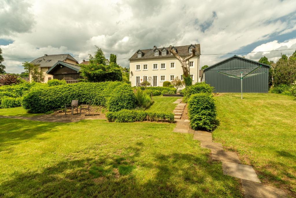 a large white house with a grass yard at Ferienwohnung Happynest in Birresborn