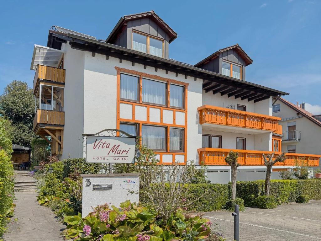 a white and orange building with a sign in front of it at Hotel Garni Vitamari in Wasserburg