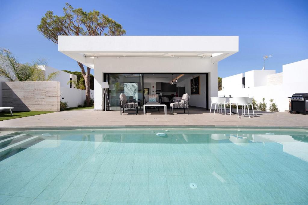 a swimming pool in front of a house at Andrea Sea Villa in Novo Sancti Petri
